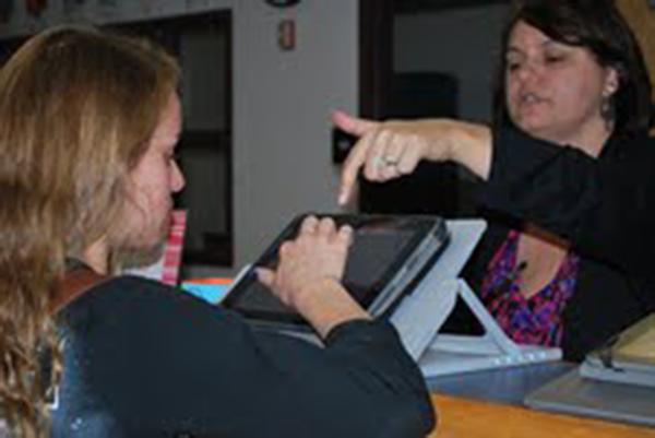 Mrs.Heaton, the new librarian is changing up the sign-in with Ipads. Jessica Ciarcia, 14, tries it out as Heaton shows her the steps.