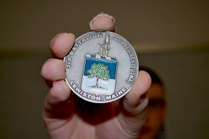 Ethan Sanborn and the military coin he earned.