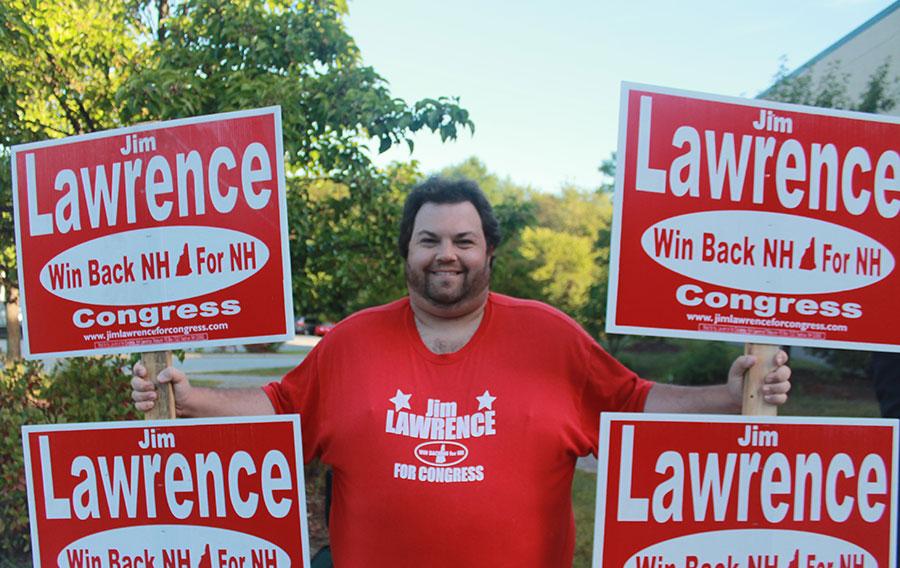 Richard Lowrance, assistant campaign manager holds signs for Jim Lawrence (r), who ran for congress but lost in the primary. Photo Credit: Julie Christie