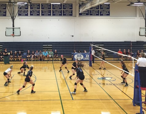 Both teams look on as Hollis Brookline's Monika Schneider '16 makes an effort to return the ball.