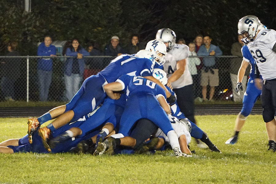 Players making a tackle during HBs 25-7 win against Sanborn