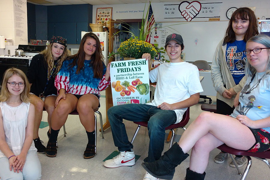 Students pose with the Farm Fresh poster. Students Eryn Bavis ‘18, Shannon Heidel ‘18, Emma Moir ‘18, Rhiannon Shebak ‘18, Ashlyn Bodholdt ‘18, Richard Huppe ‘18 are in Foods and Nutrition 2 and are helping out with the Farm Fresh Fridays for the month of October. “I think the food is tasty if you cook it right,” Emma Moir said.