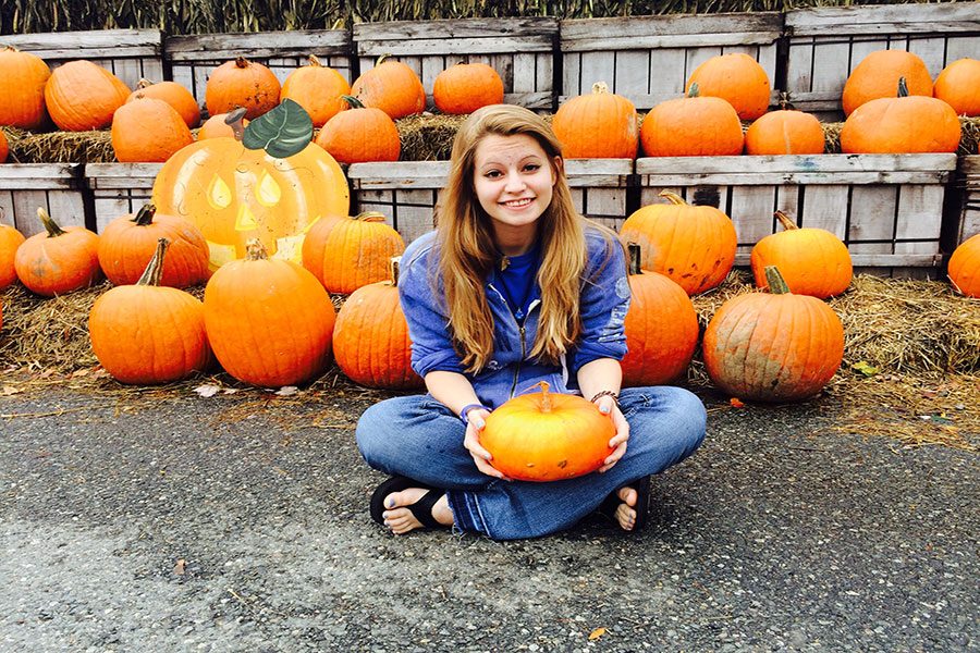 Pumped, student Rachel Romanow ‘18 lifts a pumpkin, excited for Halloween. She went pumpkin picking for the perfect pumpkin to carve. “I like this one. It’s spooky Mitchell!” said Romanow.