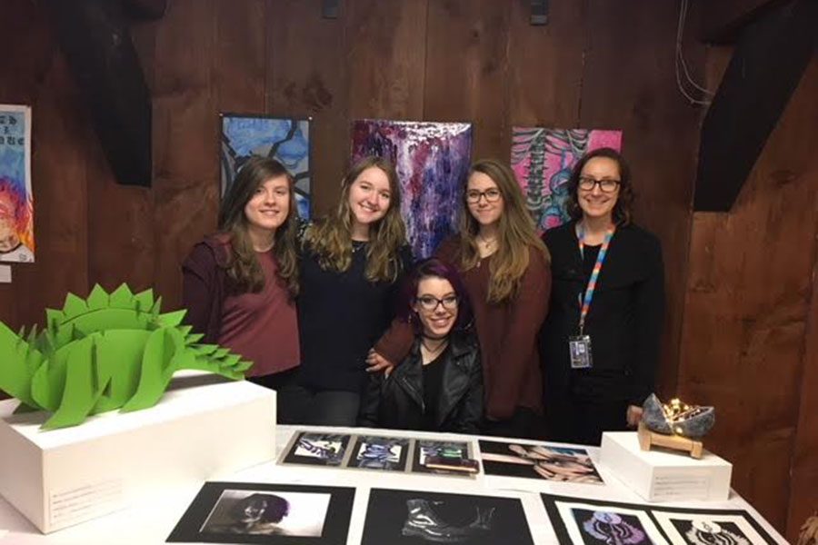 Four+seniors+took+part+in+the+show+and+displayed+their+masterpieces.+In+the+picture+is+Julia+Stam%2C+Katie+Cerato+%E2%80%9818%2C+Emily+Spooner+%E2%80%9818%2C+Maggie+Conaway+%E2%80%9818+and+Mrs.+Saunders.+%E2%80%9CAndres+Institute+people+were+happy+to+see+the+place+alive+in+the+evening%2C%E2%80%9D+said+Saunders.