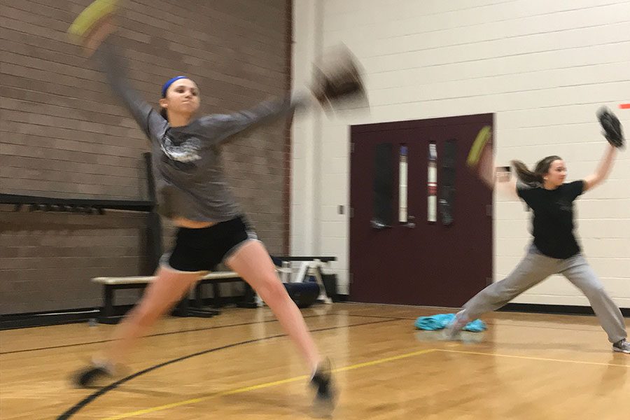 Varsity team members, Gabby Paquin ‘19 and Cassidy Pigott ‘19 pitch in the mini gym during tryouts. Both girls will be returning varsity members.“Having some fun while kicking some butt is kind of the plan… as far as I know,” said Assistant Coach Gray.  