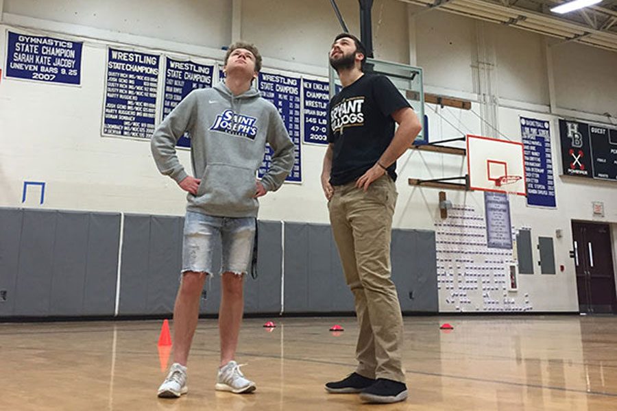 Jonathan Brunkhardt ‘18 and Scott VanCoughnett ‘18 gaze bitterly at the softball and baseball batting cage, located on the ceiling in the gymnasium. The volleyball teams have claimed that the low-lying cage gets in the way of their games. “It sucks,” says Burkhardt.
