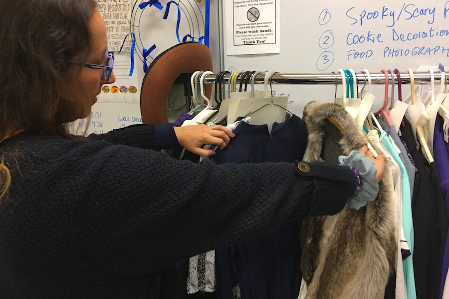 Audra Saunders examining the costumes before the fitting during CavBlock begins. She considers how they look on stage alongside each other. “It’s about showing the personality of the character and really thinking about color as well,” said Saunders.
