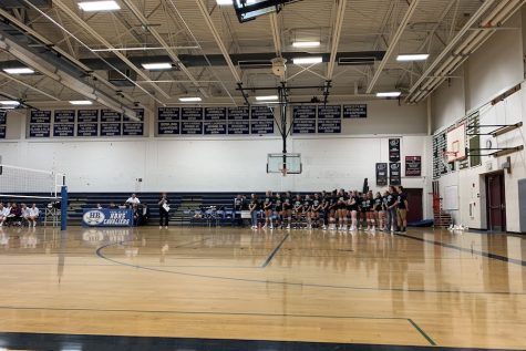 The girls line up as Coach Balfour talks reminiscently before the Kendall Van Schoick memorial game. This is one of their final home games before the Division I semifinals. “It’s a volleyball family here from the middle school, to the JV teams to the varsity team, and I think it’s great to try and create something that’s bigger than yourself, it just takes on a life of its own,” says Balfour.