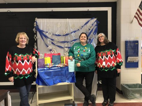 (From left to right) English Teacher Marie Salamone, Head Librarian Christine Heaton and Library Aid Alana Taylor stand in front of the Sweater Day prize cart. The second annual Sweater Day was a success! Enjoy the holiday break, HB!