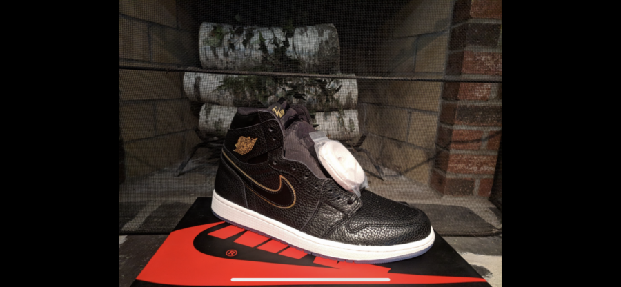 The “Air Jordan 1 Retro High OG ‘City of Flight’” is displayed on top of its shoebox. It was released in 2018, honoring Michael Jordans first all-star game in 1985. The black tumbled leather upper with the translucent outsole and the golden highlights, all elements of this shoe work together to make it a bestseller.
