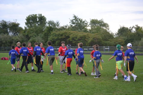 Flag football teams share an end-of-game hand tap.