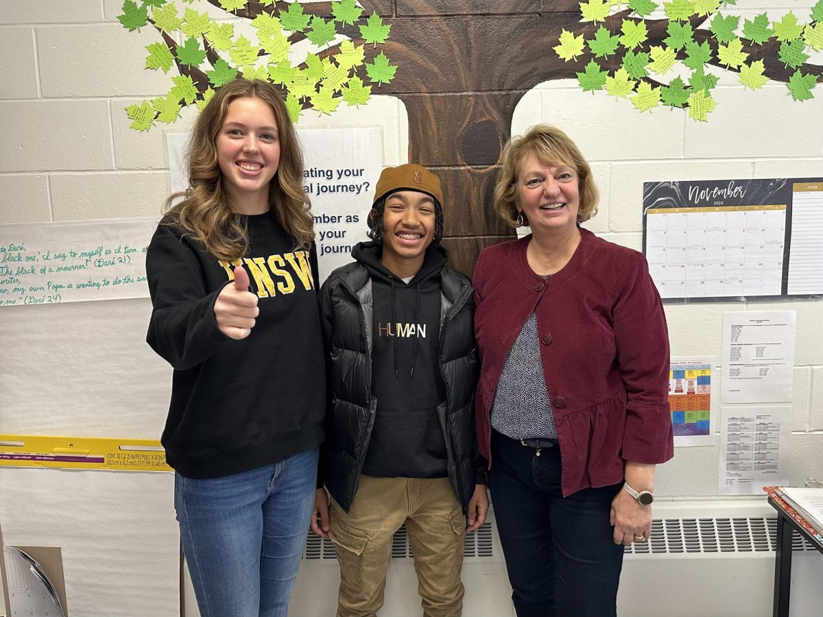 Students Lolly Adair ‘25 (left) and Y’arie Ramas ‘25 (middle) smile with their former English teacher Marie Salamone. Salamone has been teaching for over 25 years and currently instructs Accelerated English 9, Writing, College Composition and World Literature. “Bottom line, Mrs. Salamone’s the GOAT,” said Ramas.