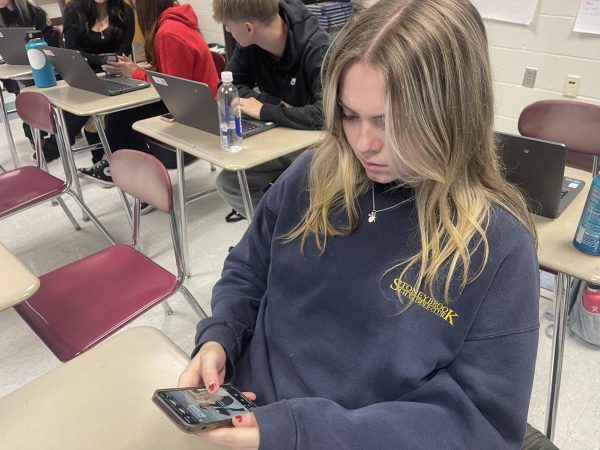 Hannah Welts ‘25 is on her phone while a lesson is being taught in class. Welts is one of many students that uses their phone in class daily. “Without the distraction of the phone, the opportunity to learn increases,” said Micheal J. Fox.
