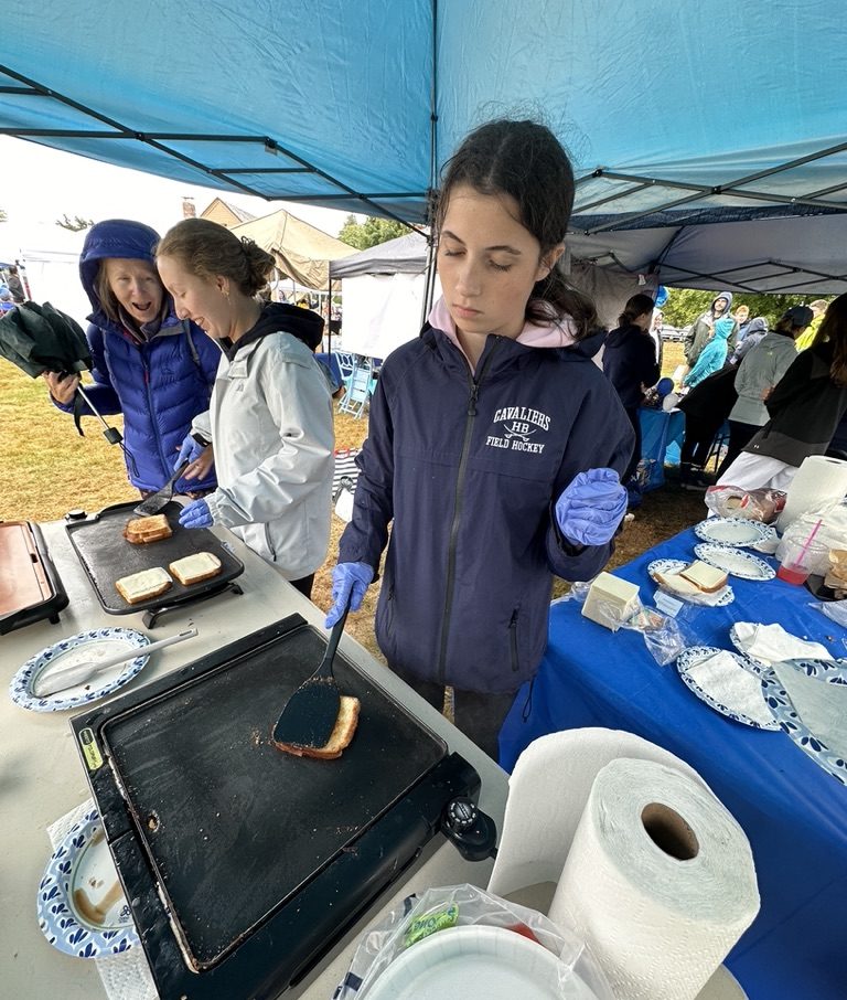 Ashley Disco ‘26 is seen at Old Home Days making grilled cheese sandwiches to support the girls' field hockey booth and raise money for their team.