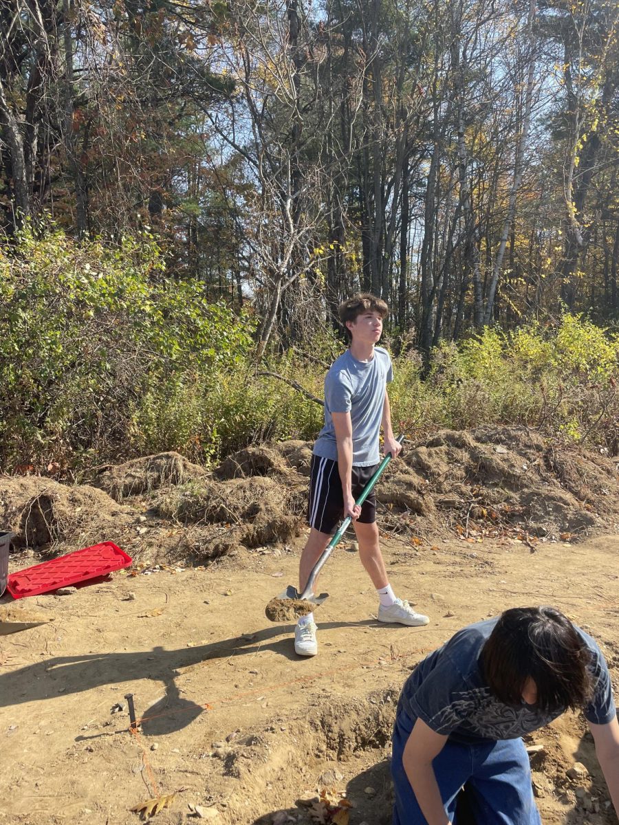 Student Brady McCammack ‘25 uses a shovel to excavate dirt from the dig site.