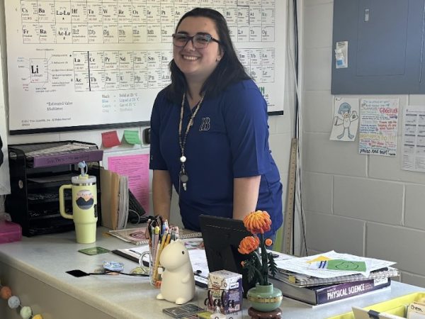 Wendling smiles in front of the periodic table behind her desk. Wendling enjoyed her picture being taken, and this is her first article. She was very excited.