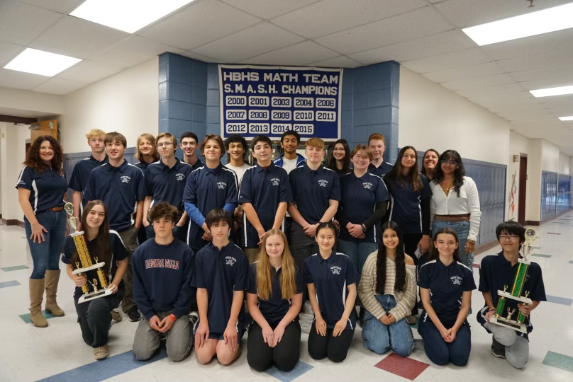 The 2024-2025 Hollis Brookline High School Math Team poses with trophies from previous years. (Courtesy HBHS Yearbook)