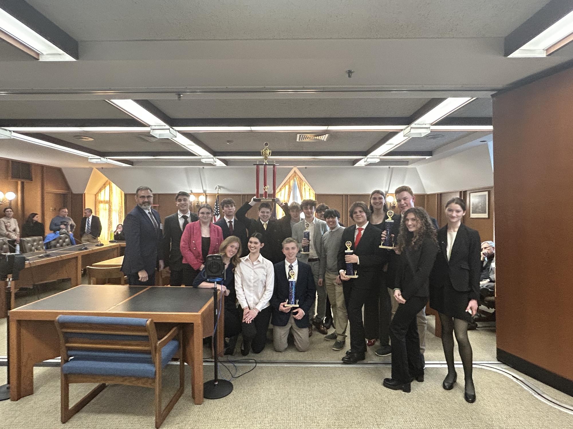 Trevor Duval and his current AP Government class after winning the New Hampshire State We the People Competition. The students worked to prepare for the competition for the entire first semester before going to the event. “The students that take AP Government are motivated, they want to do well, they want to challenge themselves, they enjoy a good discussion,” said Duval. (Image courtesy of Duval)